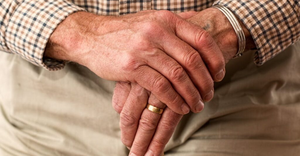 hands-walking-stick-elderly-old-person-33786 A detailed image of elderly hands clasping a wooden cane, symbolizing aging and support.