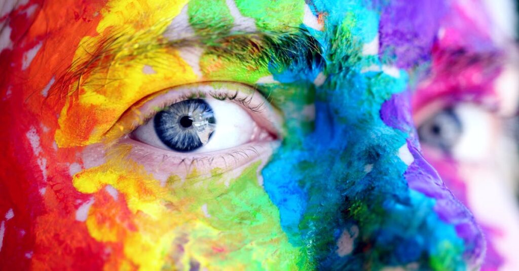 Close-up of a person with colorful rainbow face paint, symbolizing LGBT pride and expression.