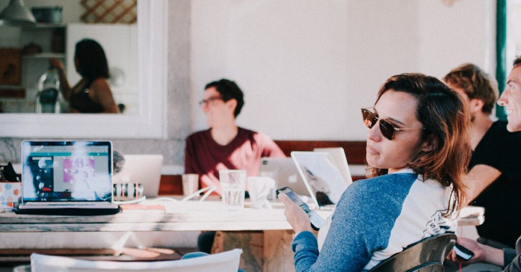 Young adults in a relaxed co-working environment, using laptops and smartphones.