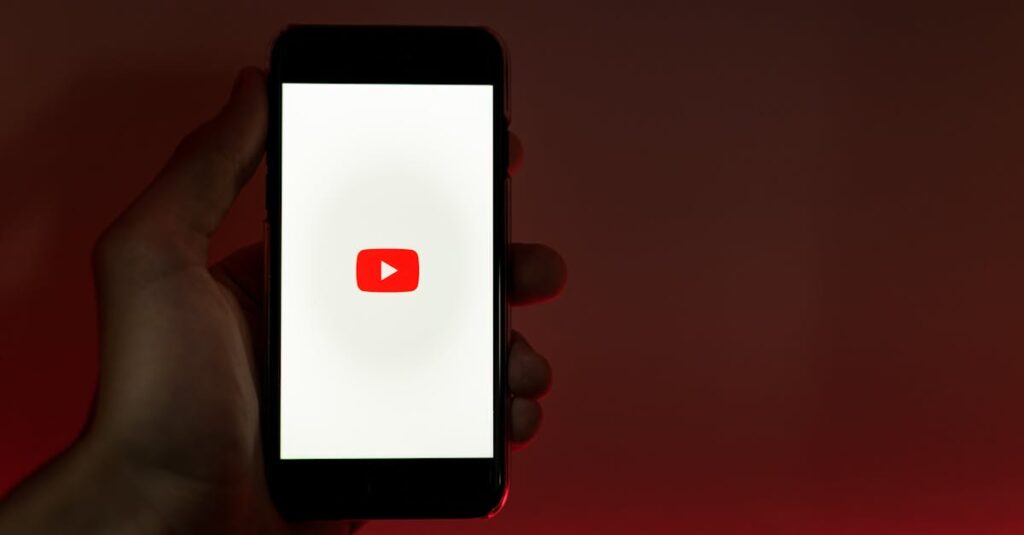 A hand holding a smartphone displaying the YouTube app against a red background.