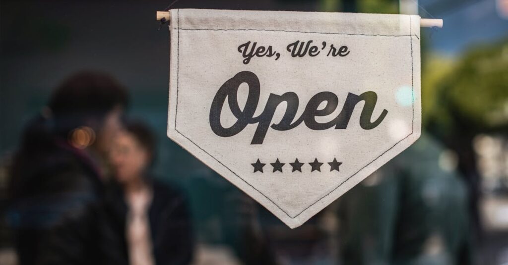 Welcoming open sign displayed in a shop window with blurred background.