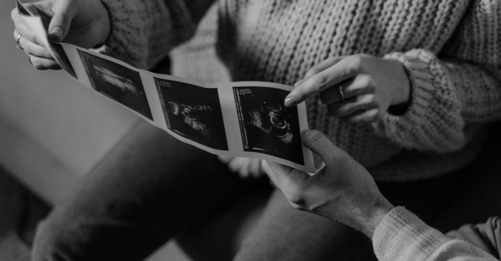 pexels-photo-6462751-6462751 Black and white photo of hands holding ultrasound images, symbolizing pregnancy journey.