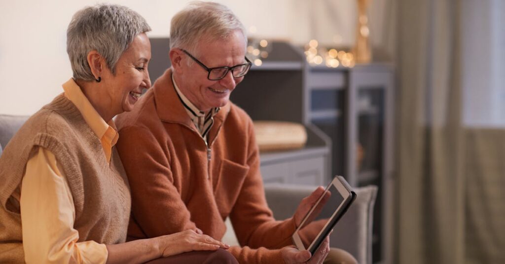 pexels-photo-6787953-6787953 A cheerful senior couple enjoying a video call on a tablet in their cozy living room.