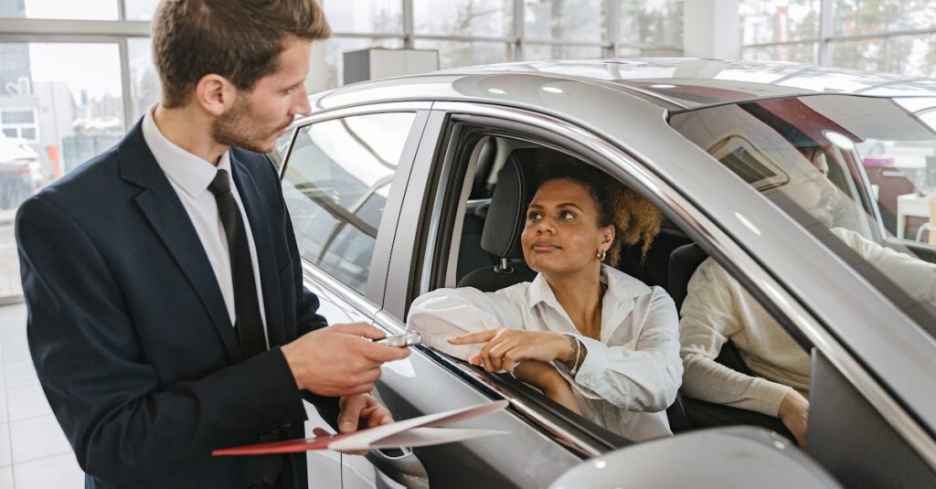 pexels-photo-7144174-7144174 A car dealer hands keys to a woman sitting inside a vehicle in a car showroom.